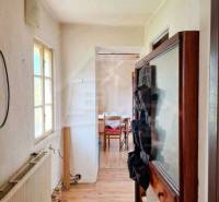 The interior of a family house with a narrow hallway and a room at the end.