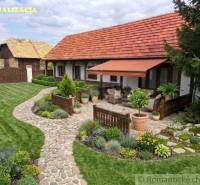 A family house in Ozdín with a flower garden and a paved terrace under an awning.