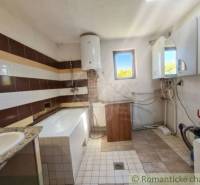 Bathroom with a tiled floor and a bathtub in a family house.
