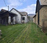 A family house in Ozdín surrounded by a grassy plot and farm buildings.