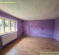 An empty room with purple walls in a family house, wooden decor flooring.