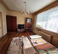 A room in a family house with a bed, a wardrobe, and a floor with a wooden decor.