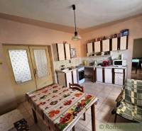 A kitchen in a family house with a dining table, kitchen unit, and appliances.