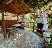 Pergola with a table and a fireplace in the gardens of Rimavská Sobota.