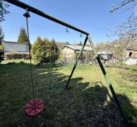 Gardens in Rimavská Sobota with a children's swing and grassy area.