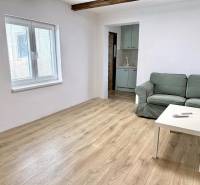Living room in a family house with a sofa, table, and floor with wooden decor.