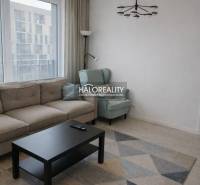 Living room with a sofa, armchair, and table, floor with wooden decor.