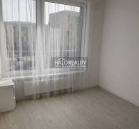 A bright room with large windows and a wooden decor floor in a 2-room apartment.