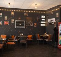 Interior of gastro spaces with car decor, chairs, and flooring with wooden decor.