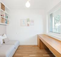 Bright room with wood-patterned flooring, a sofa, and large windows.