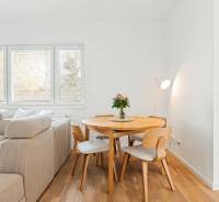 Dining area with a table and chairs in a 4-room apartment with a wooden decor floor.
