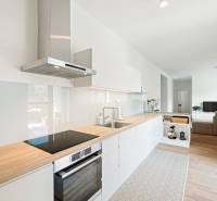 A kitchen in a 4-room apartment with a wood-patterned floor and light furnishings.