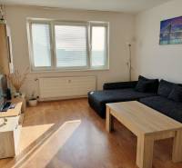Living room with a sofa, coffee table, and wood-patterned flooring in a 3-room apartment.
