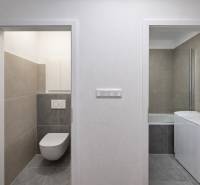 Bathroom tiles with a washing machine and toilet in a 2-room apartment.