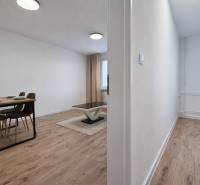 Dining area with a table and chairs in a 2-room apartment with a wooden decor floor.