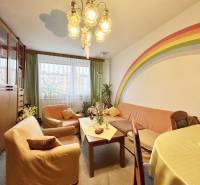 Living room in a 3-room apartment with a rainbow on the wall, comfortable sofas, and a table.