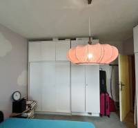 White built-in wardrobe with an interesting light fixture in a 3-room apartment.