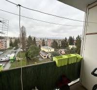 View from the balcony of a 3-room apartment on Októbrová Street in Prešov, parking lot and greenery.