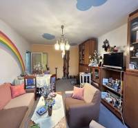 Living room in a 3-room apartment with sofas, furniture, and a painted rainbow on the wall.