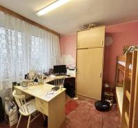 A room with a bunk bed and a desk in a three-room apartment.