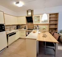 A kitchen in a 2-room apartment with a dining table and a floor with a wood decor.