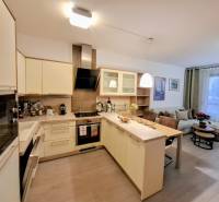 A kitchen in a 2-room apartment with a kitchen island and built-in appliances.