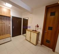 A hallway in a 2-room apartment with a shoe cabinet and a coat rack made of wood decor.