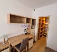 A desk with storage space in a 2-room apartment with a wooden decor floor.
