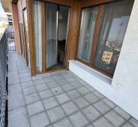 Balcony with tiles and wooden decor, part of a 2-room apartment, with railing and view.