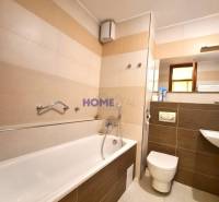 Bathroom with a bathtub, urinal, and sink in a 2-room apartment.