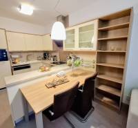 A kitchen space in a 2-room apartment with a bar counter and built-in wardrobes.