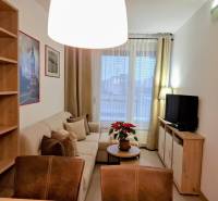 Living room in a two-room apartment with a comfortable sofa and shelves.