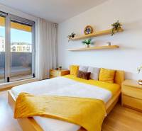 Bedroom with access to the terrace, light furniture, wooden decor flooring.