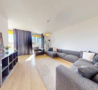 Living room with a large sofa and a wooden decor floor in a 3-room apartment.