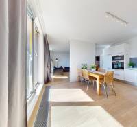 A spacious kitchen with a dining table and a wooden decor floor in a 3-room apartment.