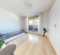 A bright room with a bed, built-in wardrobe, and wood-patterned flooring in a 3-room apartment.