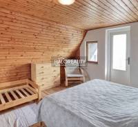 Attic room with wooden decor flooring, bright interior, and simple furnishings.