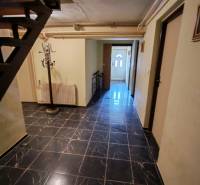 An interior with black wall tiles and a staircase in a family house.