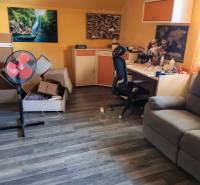 A room in a family house with a desk, a chair, and a floor with a wooden decor.