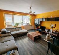 Living room of a family house with a wooden decor floor and yellow walls.