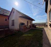 Family house in Belinciach105 with an extension, yards and grass, next to the neighboring house.