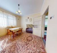 Dining area in a family house with a carpet, table, and chairs.