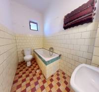 A bathroom in a family house with a bathtub, sink, and toilet, tiled.