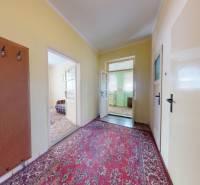 A hallway in a family house with a carpet and built-in wooden furniture.
