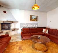 Living room with a fireplace and a sofa in a family house, with a wooden decor floor.
