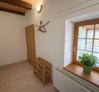 A cozy hallway in a family house with wooden elements and a plant on the windowsill.