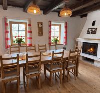 Dining room in a family house with a fireplace, wooden table, and decorative elements.