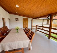 The terrace of a family house in Podbranč with a wooden ceiling and seating.
