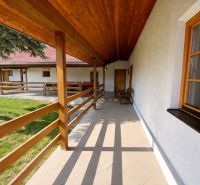 A terrace in a family house in Podbranč with wooden railings and a view of the yard.