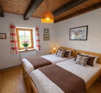 A bedroom in a family house with two beds and a floor with a wooden decor.